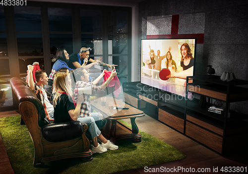 Image of Group of friends watching TV, table tennis match in England, sport games