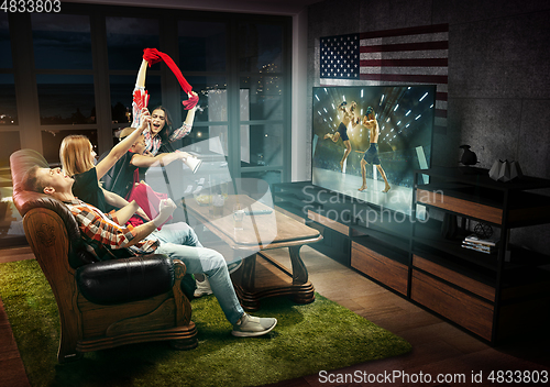 Image of Group of friends watching TV, MMA match in America, sport games