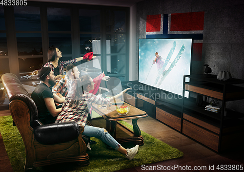 Image of Group of friends watching TV, fans of skiing in Norway, sport games