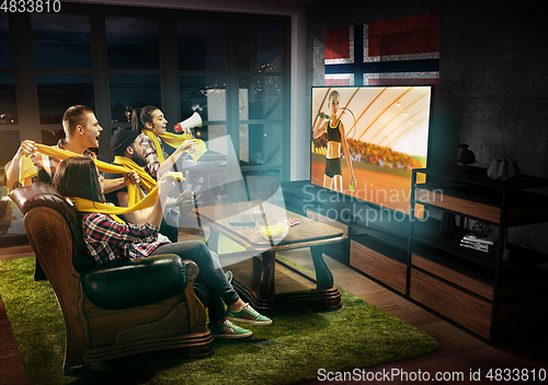 Image of Group of friends watching TV, tennis match in Norway, sport games