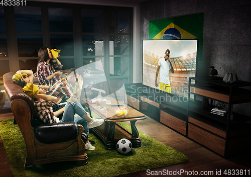 Image of Group of friends watching TV, football match in Brazil, sport games