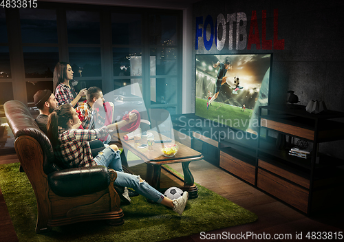 Image of Group of friends watching TV, football match in France, sport games