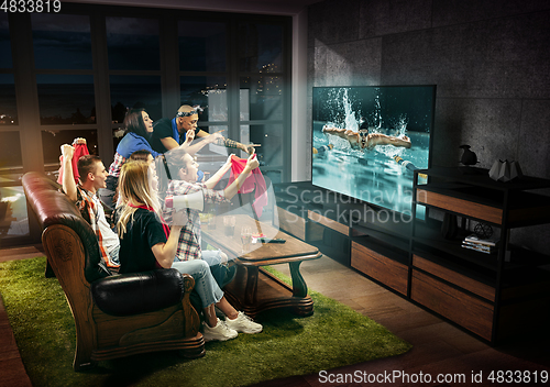 Image of Group of friends watching TV, swimming sport games