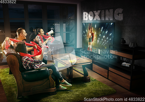Image of Group of friends watching TV, boxing match, sport games