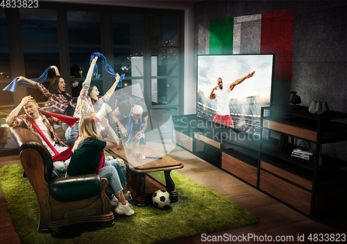 Image of Group of friends watching TV, football match in Italy, sport games