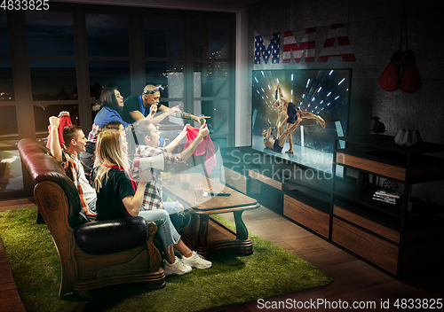 Image of Group of friends watching TV, MMA fight in USA, sport games