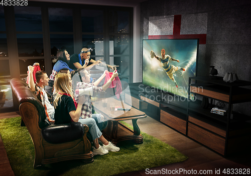 Image of Group of friends watching TV, rugby match, sport games with England flag