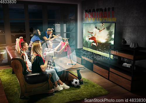 Image of Group of friends watching TV, football match in Germany, sport games