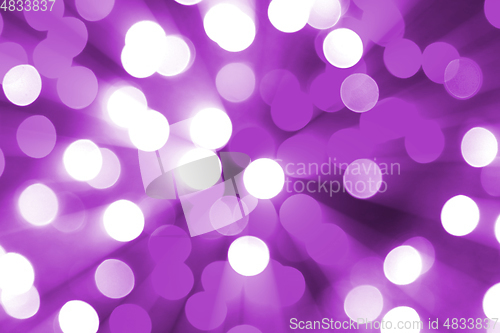 Image of Bright blurred lights and beams holiday lilac background