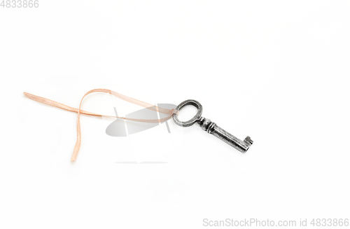 Image of Vintage silver key with pink ribbon on white background