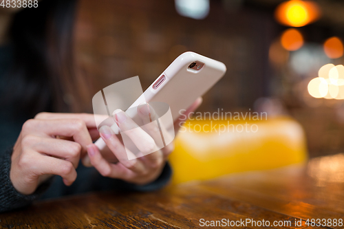Image of Woman use of mobile phone in coffee shop