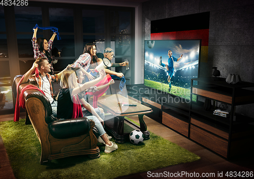 Image of Group of friends watching TV, kids football match in Germany, sport games