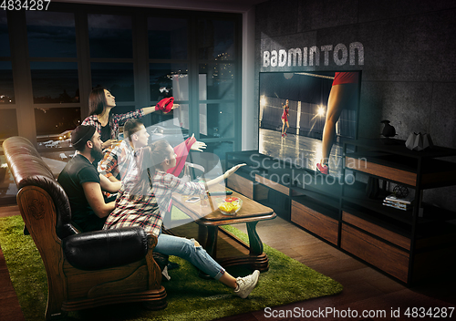 Image of Group of friends watching TV, badminton match, sport games