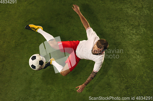 Image of Top view of caucasian football or soccer player on green background of grass