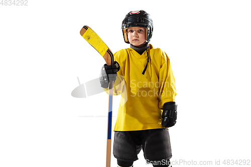 Image of Little hockey player with the stick on ice court and white studio background