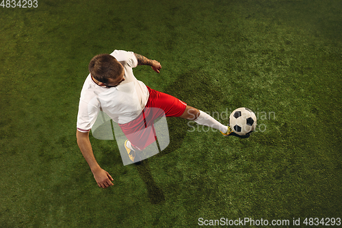 Image of Top view of caucasian football or soccer player on green background of grass