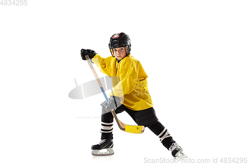 Image of Little hockey player with the stick on ice court and white studio background