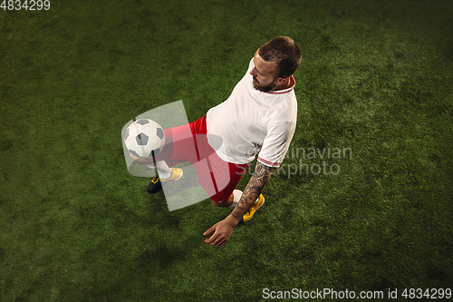Image of Top view of caucasian football or soccer player on green background of grass