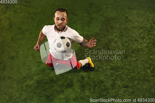 Image of Top view of caucasian football or soccer player on green background of grass