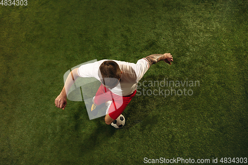 Image of Top view of caucasian football or soccer player on green background of grass