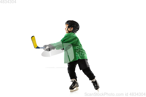 Image of Little hockey player with the stick on ice court and white studio background