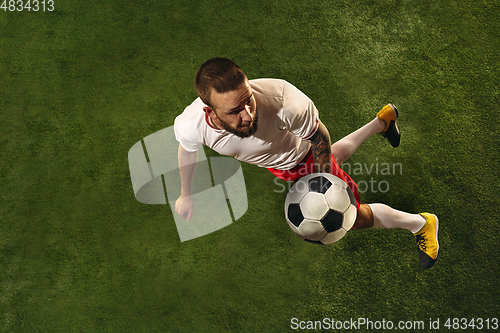 Image of Top view of caucasian football or soccer player on green background of grass