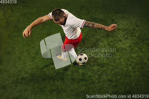 Image of Top view of caucasian football or soccer player on green background of grass