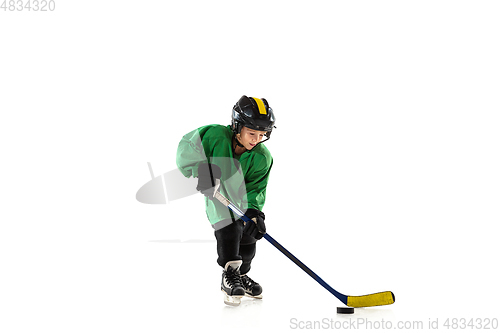 Image of Little hockey player with the stick on ice court and white studio background