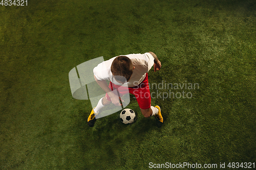 Image of Top view of caucasian football or soccer player on green background of grass