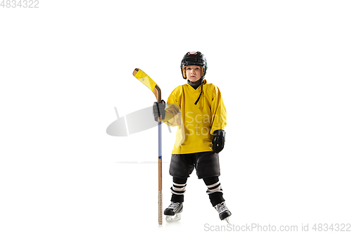 Image of Little hockey player with the stick on ice court and white studio background