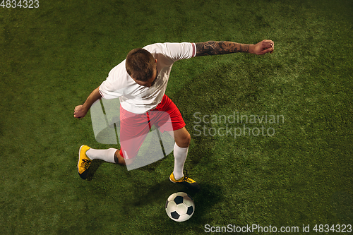 Image of Top view of caucasian football or soccer player on green background of grass