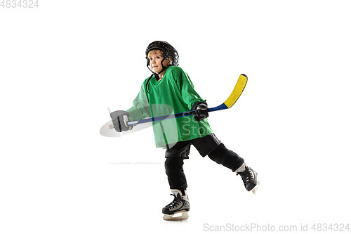 Image of Little hockey player with the stick on ice court and white studio background