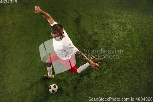 Image of Top view of caucasian football or soccer player on green background of grass