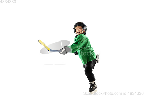 Image of Little hockey player with the stick on ice court and white studio background