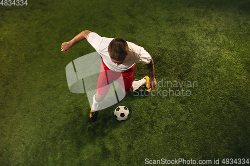 Image of Top view of caucasian football or soccer player on green background of grass