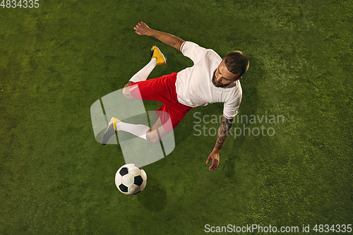 Image of Top view of caucasian football or soccer player on green background of grass