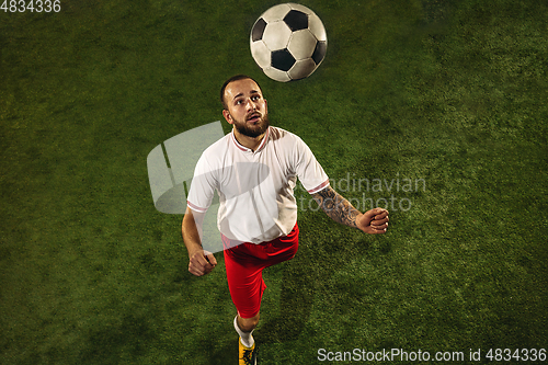 Image of Top view of caucasian football or soccer player on green background of grass