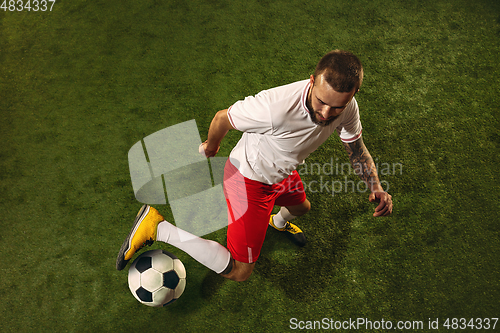 Image of Top view of caucasian football or soccer player on green background of grass