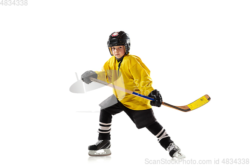 Image of Little hockey player with the stick on ice court and white studio background