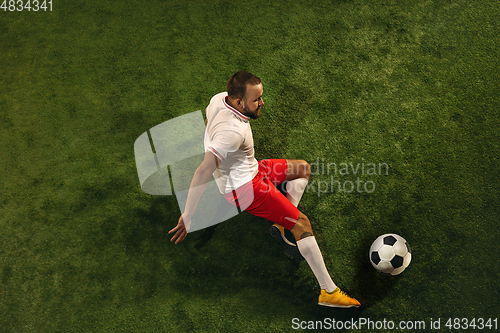 Image of Top view of caucasian football or soccer player on green background of grass