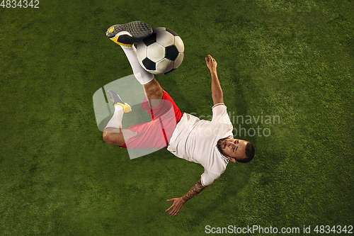 Image of Top view of caucasian football or soccer player on green background of grass