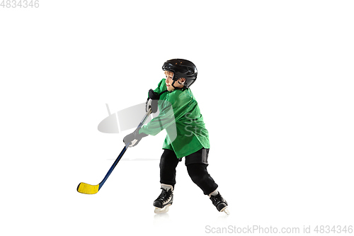 Image of Little hockey player with the stick on ice court and white studio background