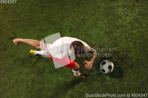 Image of Top view of caucasian football or soccer player on green background of grass