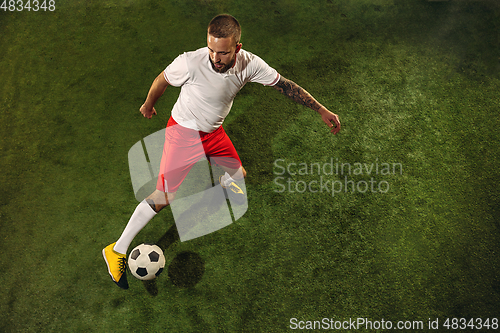Image of Top view of caucasian football or soccer player on green background of grass