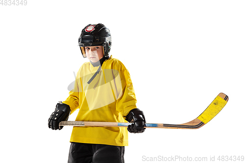 Image of Little hockey player with the stick on ice court and white studio background