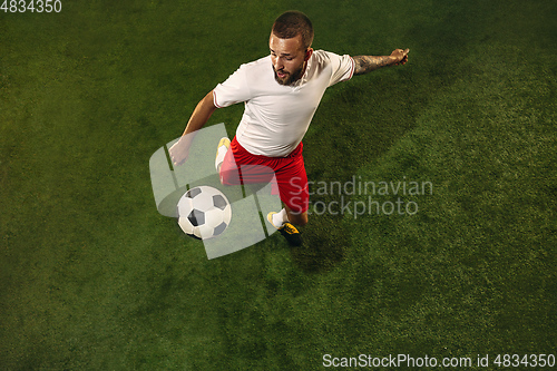 Image of Top view of caucasian football or soccer player on green background of grass