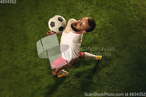 Image of Top view of caucasian football or soccer player on green background of grass