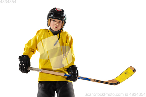 Image of Little hockey player with the stick on ice court and white studio background