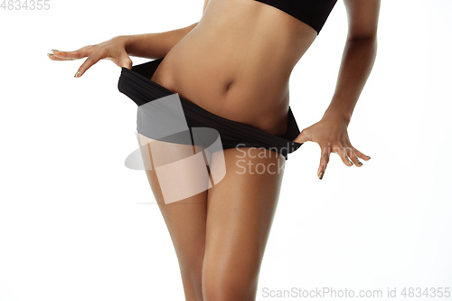 Image of Slim tanned woman\'s body isolated on white studio background