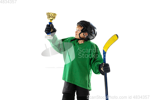 Image of Little hockey player with the stick on ice court and white studio background